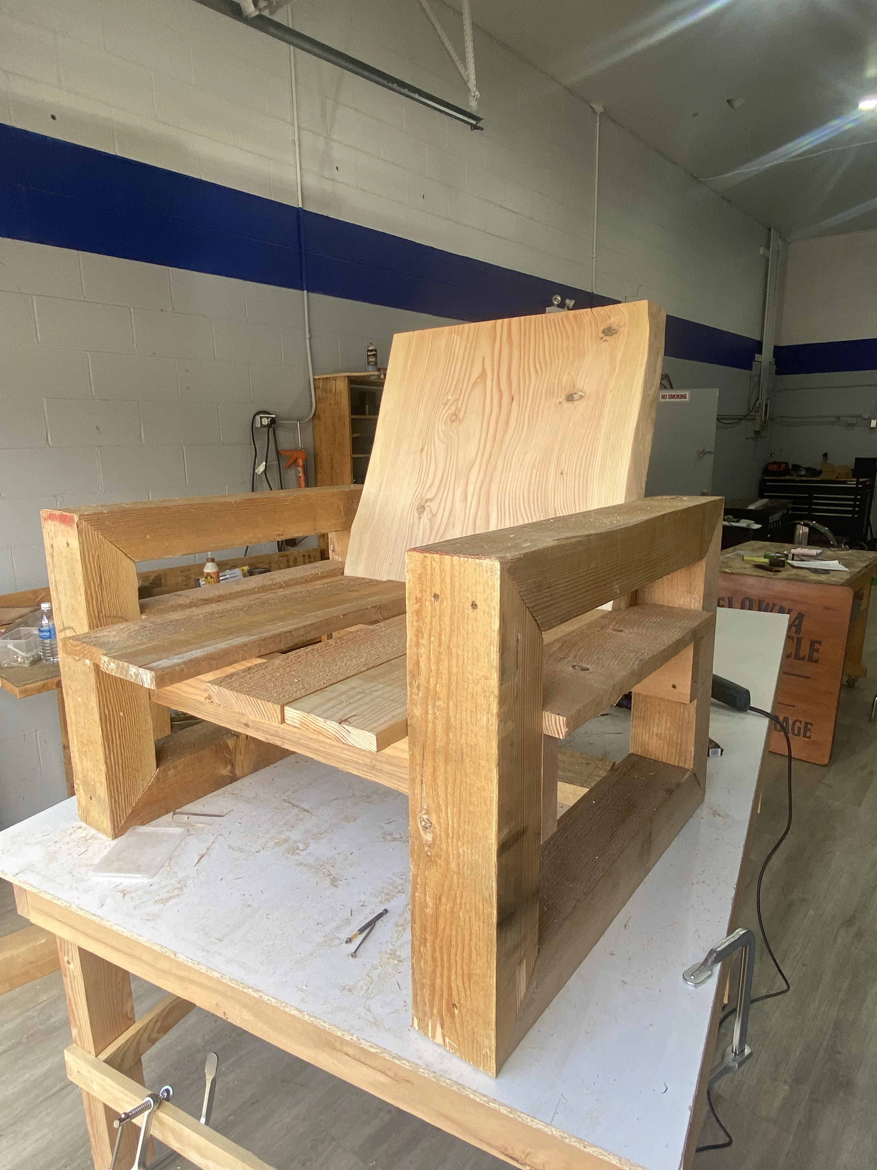 Custom cedar lounge chair being assembled on a workbench in the shop